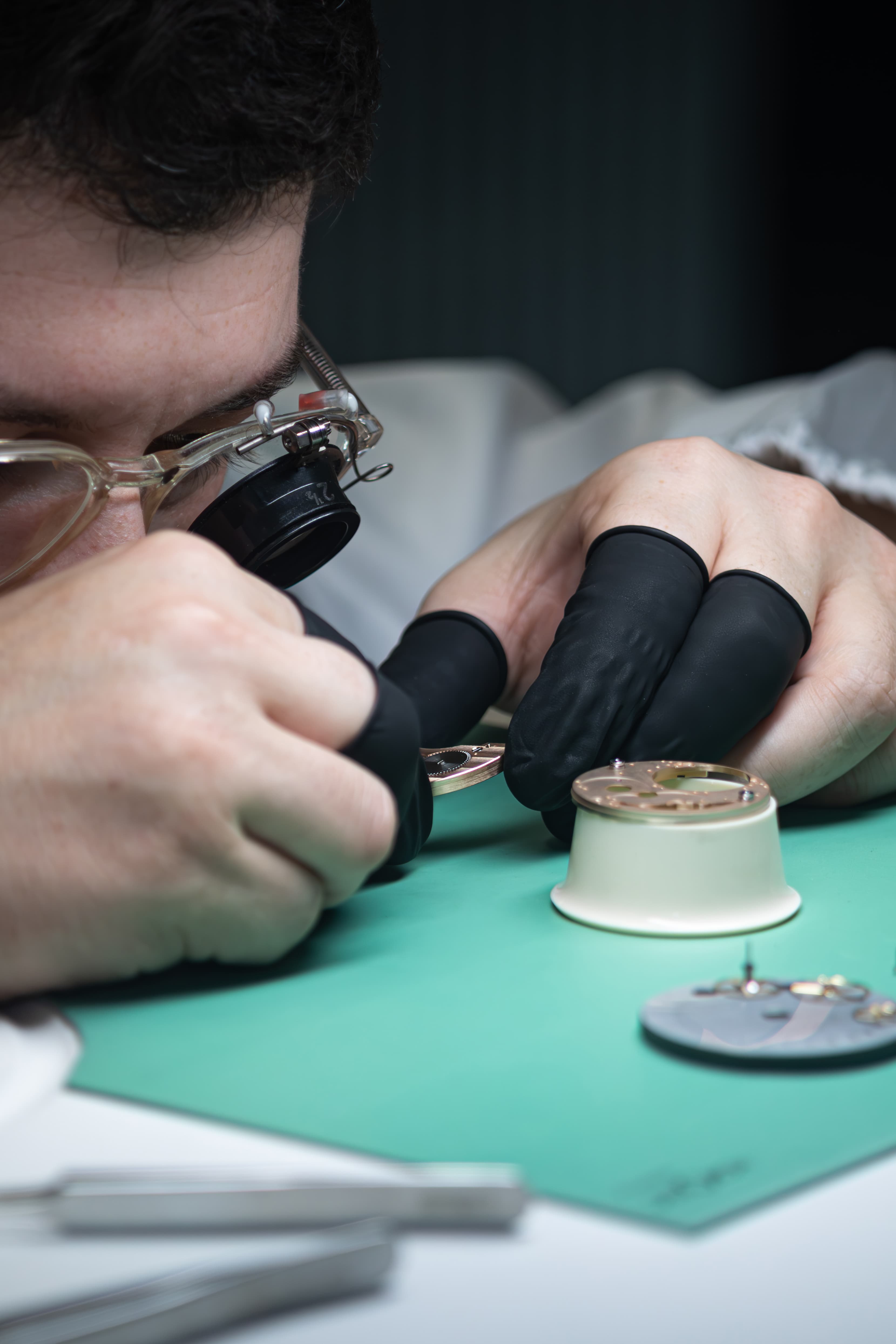 Watchmaker hand-assembling movement components